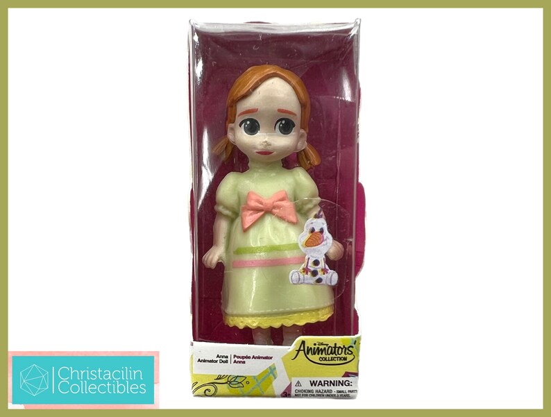 May include: A Disney Animators' Collection Anna doll in a clear plastic display case. The doll wears a light green dress with a pink bow and holds a small Olaf figure. The packaging includes the Disney Animators' Collection logo.