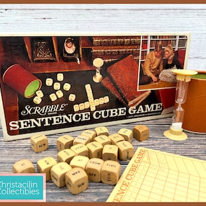 May include: Vintage Scrabble Sentence Cube Game box set with dice, timer, and score sheet. The box features a brown and white design with the game title. The dice are wooden with printed letters and words. A fun board game for all ages.