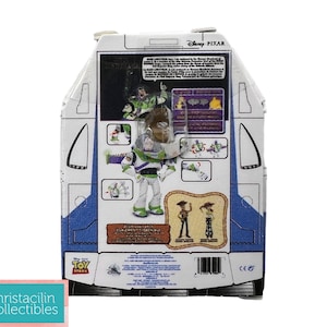 Puede incluir: Una figura de acci&oacute;n de Buzz Lightyear en su embalaje original. El embalaje es blanco con detalles en azul y presenta im&aacute;genes del personaje y otros personajes de la franquicia Toy Story. La parte posterior del embalaje incluye texto e ilustraciones.