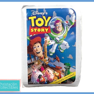 May include: A vintage Disney's Toy Story VHS tape. The cover features Woody, Buzz Lightyear, and other characters against a blue background. The text "Toy Story" is prominently displayed.