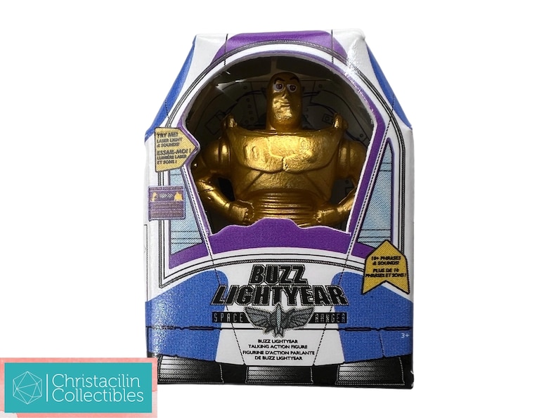 Puede incluir: Figura de acci&oacute;n de Buzz Lightyear dorada en su caja original. La caja presenta un dise&ntilde;o azul, blanco y morado con las palabras "Buzz Lightyear Space Ranger". La figura es visible a trav&eacute;s de una ventana transparente.