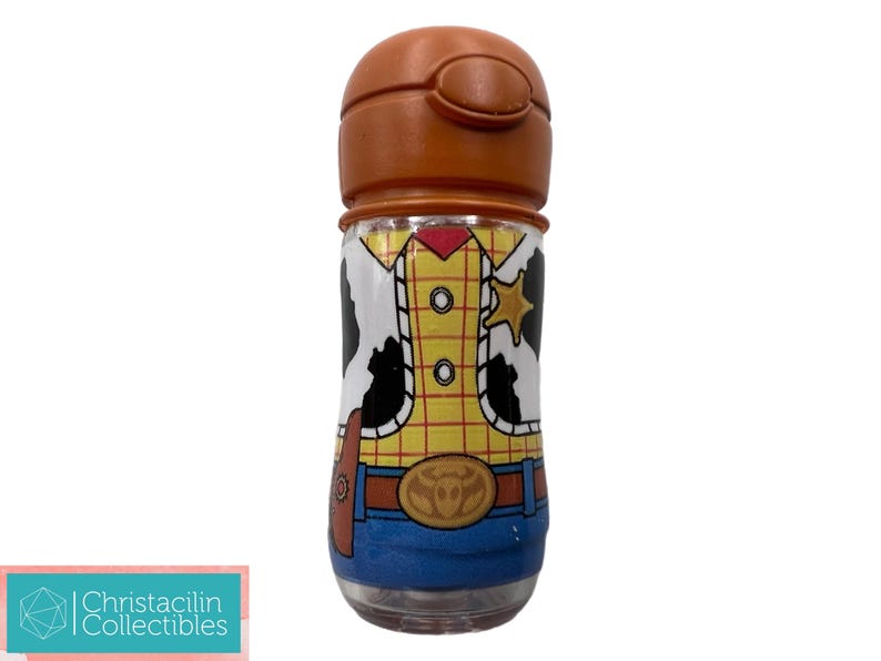 May include: A clear, cylindrical water bottle with a brown lid. The bottle is decorated with a design resembling the character Woody from Toy Story, featuring a yellow shirt, blue jeans, and a sheriff's badge.