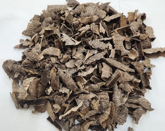 May include: A pile of brown, chipped wood pieces, possibly bark or a similar natural material, is displayed against a white background. The pieces vary in size and shape, with a rough, textured appearance. The color ranges from light to dark brown.