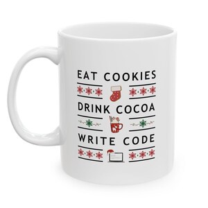 Peut inclure: Mug en céramique blanche avec un motif de Noël. Le mug présente le texte "Eat Cookies, Drink Cocoa, Write Code" avec des icônes festives.