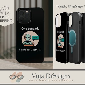May include: Black phone cases with a robot design and the text "One second, Let me ask ChatGPT." The cases are MagSafe compatible. The cases are displayed on a wooden surface. The cases have a sleek, modern look.