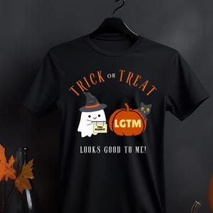 Op de afbeelding: Zwart T-shirt met oranje tekst "Trick or Treat". Een spook met een heksenhoed houdt een "Pull Request" bord vast. Een pompoen met "LGTM" en een zwarte kat zijn ook te zien. De zin "Looks Good To Me!" staat eronder.