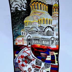 May include: A colorful silk scarf with a painting of a church with a black and white striped facade and a red, white, and blue patterned design at the bottom. The artist's signature "LUESAROVA" is visible in the bottom right corner.