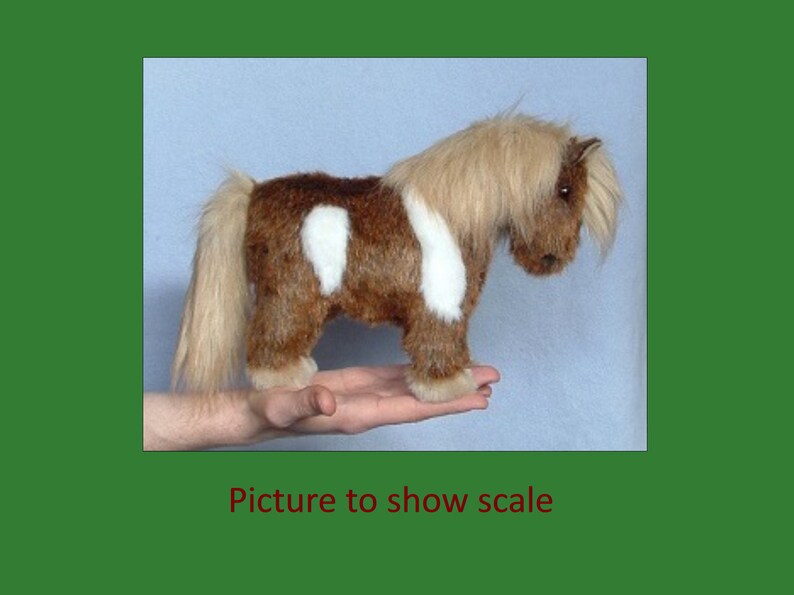 Puede incluir: Un pony de peluche marr&oacute;n y blanco con una larga melena y cola. El pony est&aacute; de pie sobre la mano de una persona para mostrar su tama&ntilde;o.