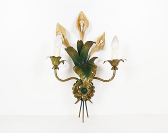 Peut inclure: Applique murale décorative de style vintage avec un motif floral. La lampe comprend deux ampoules et est fabriquée en métal avec des tons verts, dorés et bruns. Le design comprend des feuilles et des accents floraux.