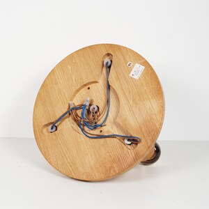 K&ouml;nnte beinhalten: Die Unterseite einer Deckenleuchte aus Holz mit freiliegenden Kabeln und drei wei&szlig;en Kunststoff-Elektroanschl&uuml;ssen.