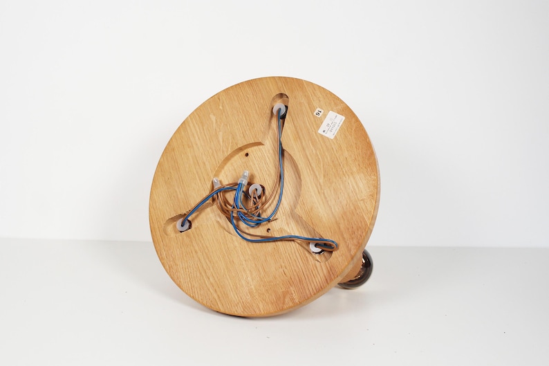 K&ouml;nnte beinhalten: Die Unterseite einer Deckenleuchte aus Holz mit freiliegenden Kabeln und drei wei&szlig;en Kunststoff-Elektroanschl&uuml;ssen.
