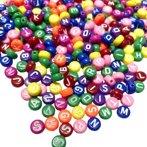 May include: A collection of alphabet beads in a variety of colours, such as red, blue, green, yellow, and pink. Each bead has a white letter. These beads are suitable for jewellery making and craft projects.