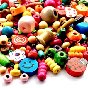 May include: A collection of colourful wooden beads in various shapes and sizes, including flowers, swirls, and ladybirds. The beads are perfect for crafting jewellery, garlands, or other decorative projects.