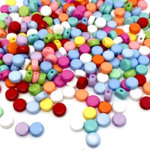 May include: A large assortment of colourful round plastic beads with a hole in the centre. The beads are in various shades of pink, blue, green, yellow, orange, and white.