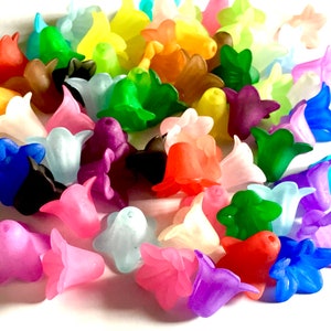 May include: A collection of colourful plastic flower beads in various shades of blue, green, purple, pink, red, yellow, and white. The beads are shaped like bell flowers and are perfect for crafting.