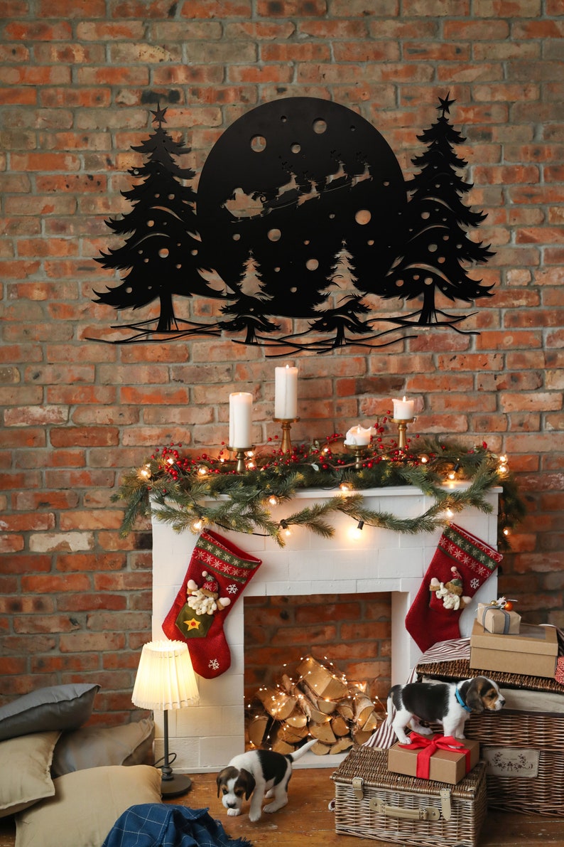 K&ouml;nnte beinhalten: Eine schwarze Wanddekoration aus Metall mit einer Silhouette von Weihnachtsmann, der mit Rentieren in einem Schlitten &uuml;ber einem Mond und B&auml;umen fliegt. Die Dekoration h&auml;ngt &uuml;ber einem wei&szlig;en Kaminsims, der mit einem Kranz aus Gr&uuml;n, Lichtern und roten Str&uuml;mpfen geschm&uuml;ckt ist. Zwei Beagle-Welpen sitzen vor dem Kamin.