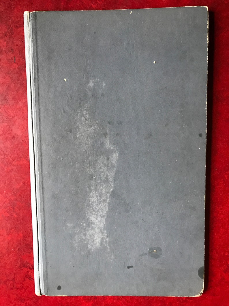 May include: A gray hardcover book with a worn, textured cover. The book has a slight discoloration on the front cover.