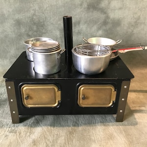 Antique children&#39;s stove 1930 with pots and pans