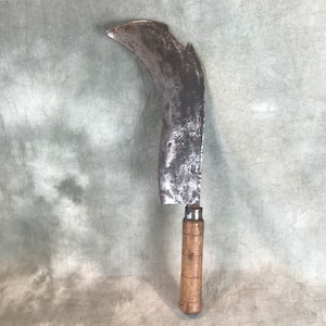 May include: A curved, metal blade with a wooden handle. The blade is rusty and has a chipped edge. The handle is made of wood and has a brown finish.