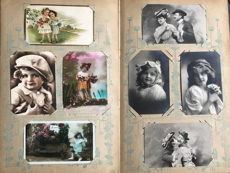 May include: An antique photo album filled with vintage postcards featuring children and couples. The album has a brown leather cover with a decorative design.