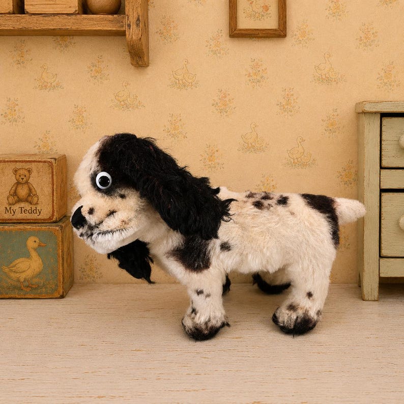 K&ouml;nnte beinhalten: Ein Pl&uuml;schhund mit schwarz-wei&szlig;em Fell, ausgestattet mit einem sichtbaren Wackelauge, Schlappohren und dunklen Flecken auf R&uuml;cken und Beinen. Das Stofftier steht auf vier Beinen, hat einen kurzen Schwanz und eine weiche, strukturierte Oberfl&auml;che.