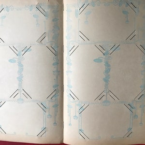 May include: An open photo album with decorative blue and black borders on each page. The pages are blank and ready for photos.