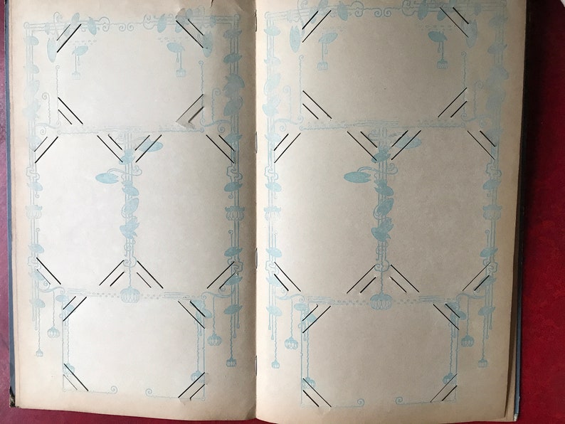 May include: An open photo album with decorative blue and black borders on each page. The pages are blank and ready for photos.
