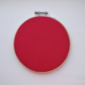 K&ouml;nnte beinhalten: Ein roter Stickrahmen mit einem Holzrahmen.