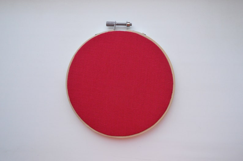 K&ouml;nnte beinhalten: Ein roter Stickrahmen mit einem Holzrahmen.