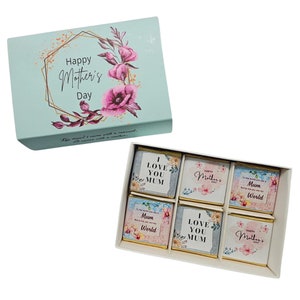 May include: A light blue box with a floral design and the text "Happy Mother's Day". The box contains six chocolate squares with floral designs and messages like "I Love You Mum" and "To the world you are a Mum but to me you are my World".