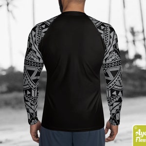 May include: Black long-sleeve shirt with a geometric pattern in gray on the sleeves. The shirt has a black raglan sleeve design.