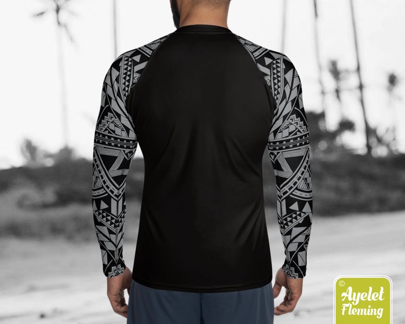 May include: Black long-sleeve shirt with a geometric pattern in gray on the sleeves. The shirt has a black raglan sleeve design.