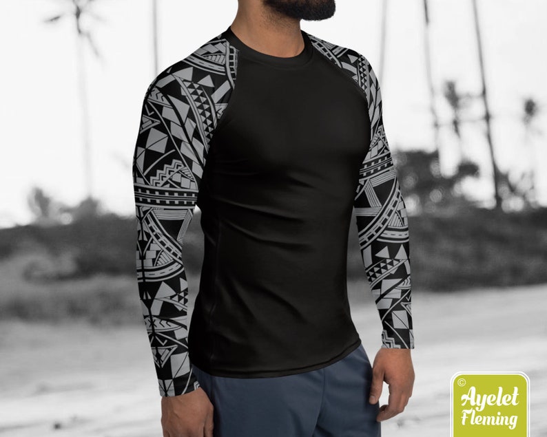 May include: Black long-sleeve shirt with a geometric pattern in white and gray on the sleeves. The shirt is made of a stretchy, athletic material.