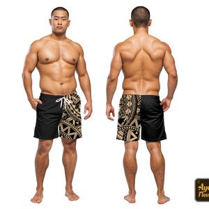 May include: A person wearing black swim trunks with a gold tribal pattern on the side. The trunks have a white drawstring.