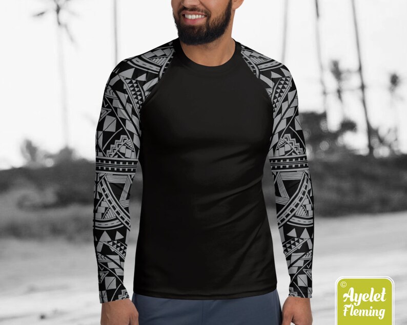May include: Black long-sleeve shirt with a geometric pattern in gray on the sleeves. The shirt is made of a stretchy, moisture-wicking fabric.