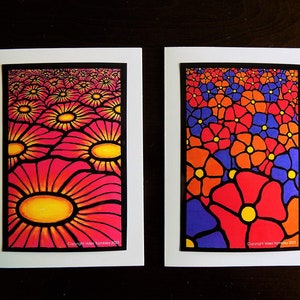 May include: Two greeting cards with black borders and white backgrounds. The left card features a repeating pattern of pink and orange flowers with yellow centers. The right card features a repeating pattern of red, orange, and purple flowers with yellow centers. Both cards have the text "Copyright Violet Tomley 2021" in the bottom right corner.