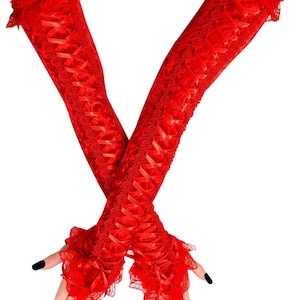 May include: A pair of long, red lace gloves with a ruffled edge at the wrist and hand. The gloves feature a crisscross ribbon design and are made of a delicate, sheer fabric. The nails are painted black.