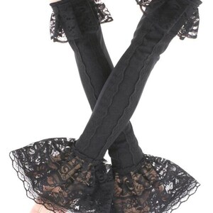 May include: Black arm warmers with intricate lace cuffs and trim. The arm warmers are made of a stretchy, ribbed material and feature a delicate lace design at the wrist and upper arm. The cuffs are flared and add a touch of elegance.