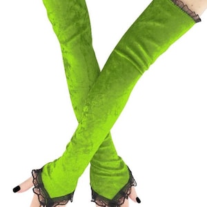 Può includere: Lunghi guanti in velluto verde brillante con bordi in pizzo nero sui polsi e sulle dita. I guanti sono di un colore vivace e accattivante.