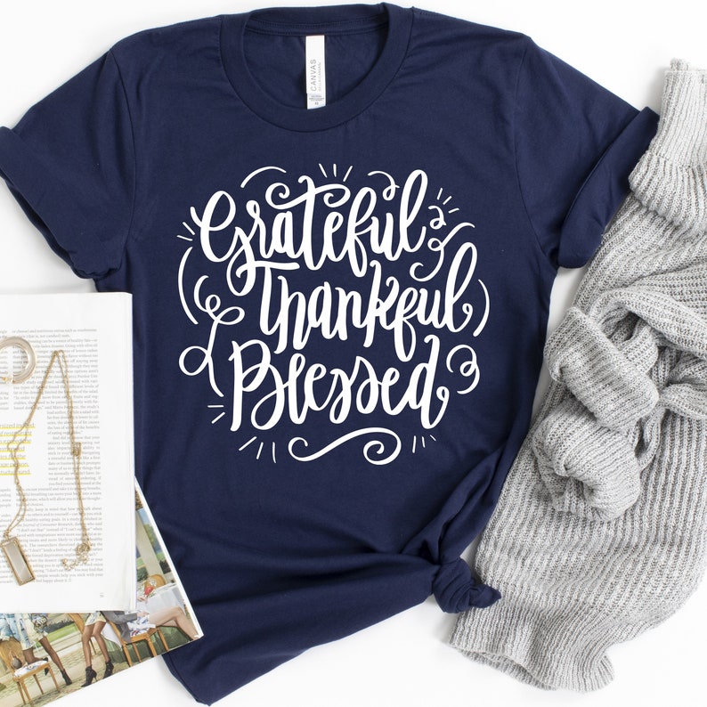 May include: A navy blue t-shirt with white lettering that reads "Grateful Thankful Blessed".