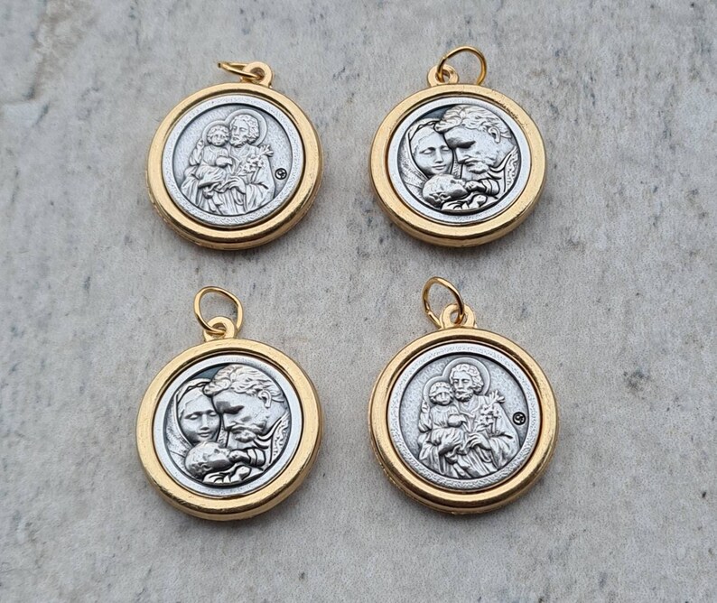 May include: Four gold-toned pendants with silver-toned images of a family. Each pendant features a different image of a man, woman, and child.