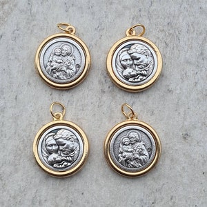 May include: Four silver and gold pendants featuring a religious image of a family. The pendants are round and have a gold rim.