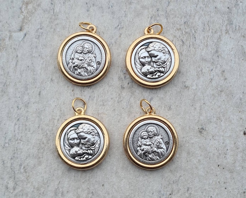 May include: Four silver and gold pendants featuring a religious image of a family. The pendants are round and have a gold rim.