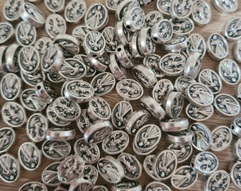 May include: A collection of silver-colored oval beads. Each bead features a detailed relief image of a figure with rays of light. The beads are scattered, showing their detailed design and texture. These beads are suitable for jewelry making.
