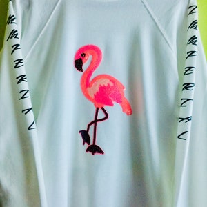 Moletom feminino leve com estampa de flamingos em tecido atoalhado felpudo.