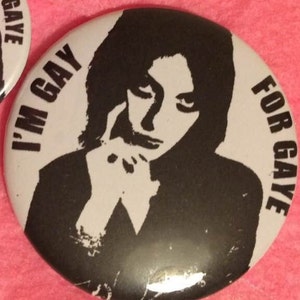 May include: Black and white button with a silhouette of a person with the text "I'm Gay" and "For Gay" on a white background.