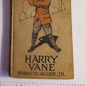 Op de afbeelding: Een vintage boekomslag met een bruine achtergrond waarop een zwart-witte illustratie van een man die golf speelt. De titel van het boek is "HARRY VANE" en de auteur is "HORATIO ALGER, JR."