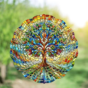 May include: A colorful, round stained glass art piece featuring a tree design. The tree has a brown trunk and branches with green leaves and red berries. The background is a mosaic of blue, yellow, orange, and green glass pieces.