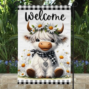 Può includere: Una bandiera da giardino con una mucca delle Highlands dei cartoni animati con una corona di margherite e una sciarpa a scacchi bianchi e neri. La bandiera ha la scritta "Welcome" in nero in alto e un bordo a scacchi bianchi e neri.