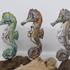 Painted wooden seahorse on stand.